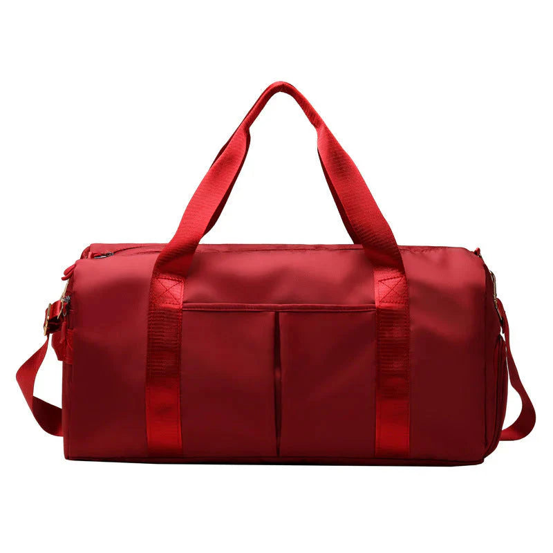 Mala desportiva impermeável vermelha com alças e bolso frontal, ideal para viagens e atividades desportivas.