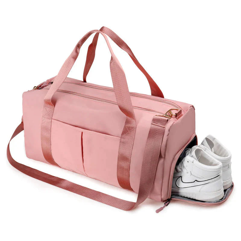 Mala desportiva impermeável vermelha com alças e bolso frontal, ideal para viagens e atividades desportivas.