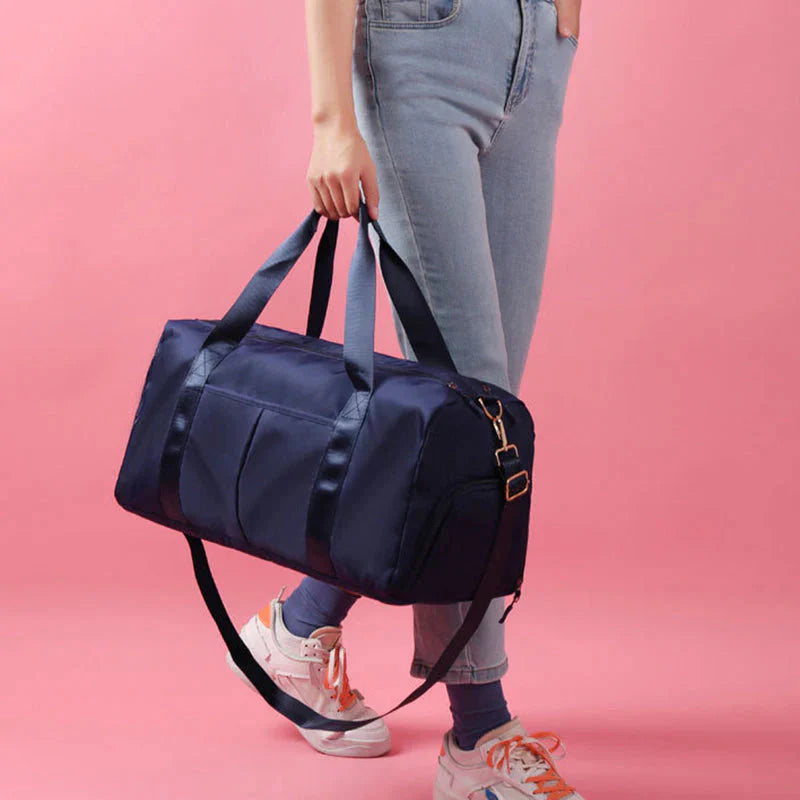 Mala desportiva impermeável vermelha com alças e bolso frontal, ideal para viagens e atividades desportivas.