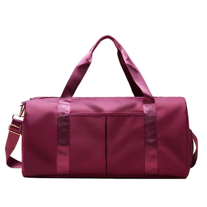 Mala desportiva impermeável vermelha com alças e bolso frontal, ideal para viagens e atividades desportivas.