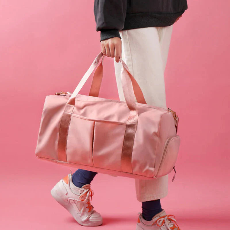 Mala desportiva impermeável vermelha com alças e bolso frontal, ideal para viagens e atividades desportivas.